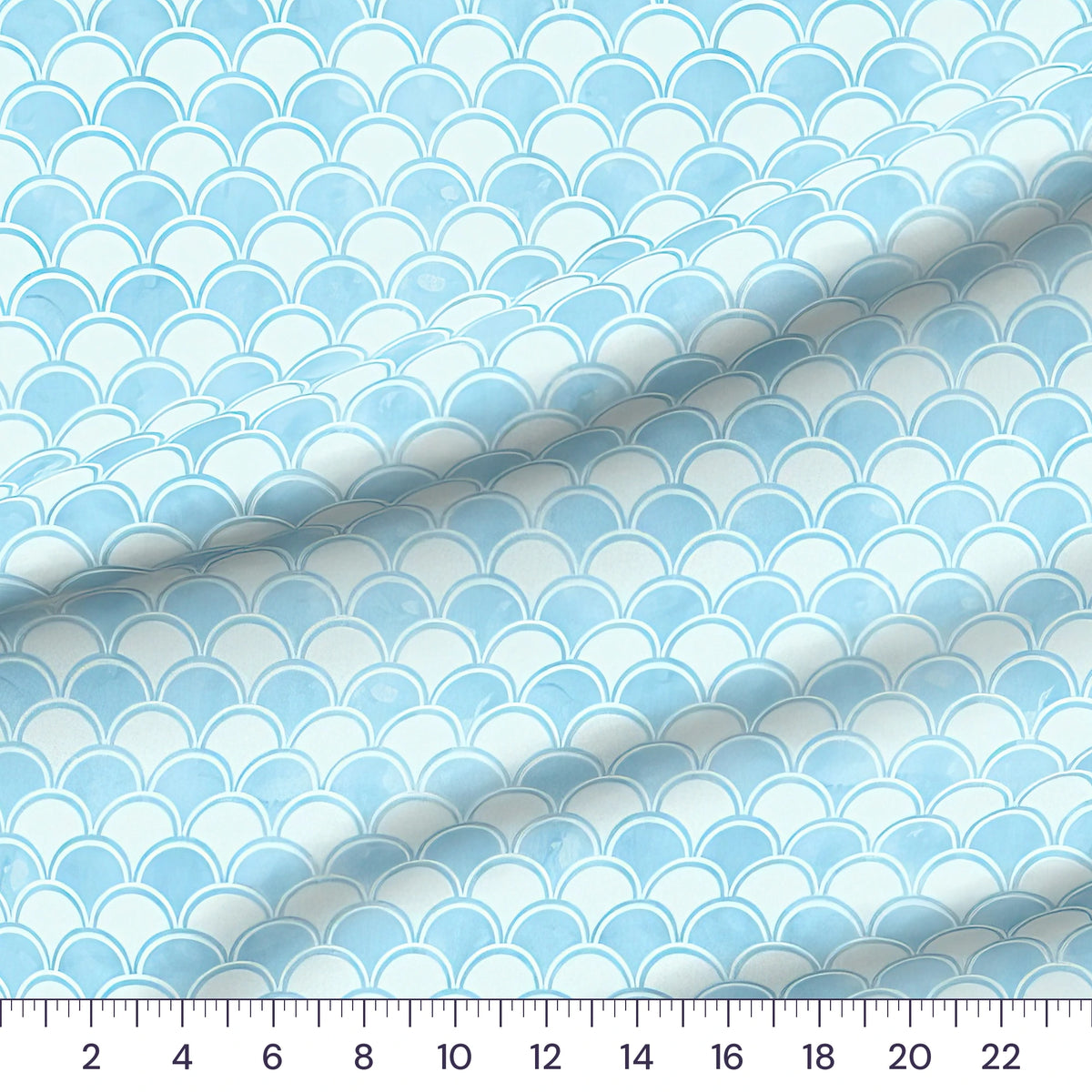 Whimsical Whale Scallop Waves quilting cotton fabric draped close-up with a ruler showing true print scale