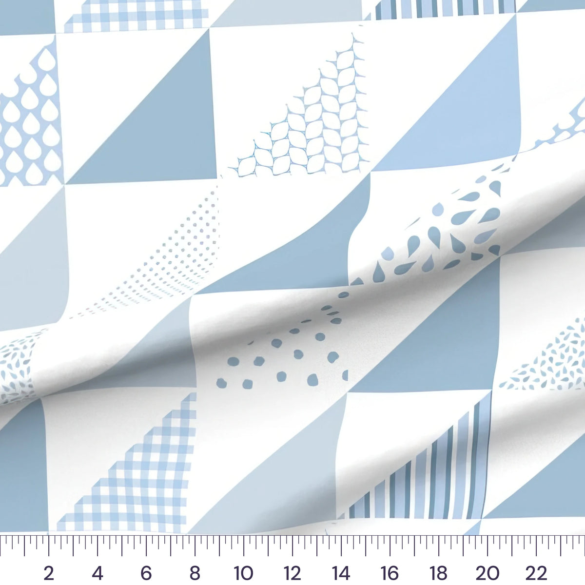Blue half-square triangle cheater quilt fabric by the yard with 6 inch blocks, draped quilting cotton with a ruler showing true scale