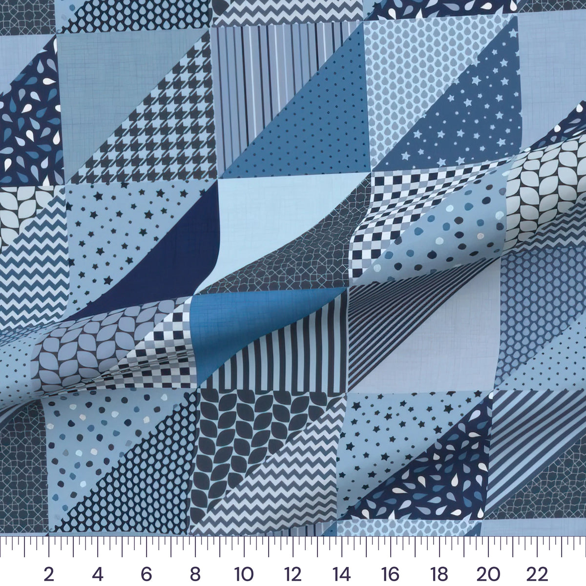 Denim blue patchwork cheater quilt fabric by the yard with 6 inch blocks, draped quilting cotton with a ruler showing true scale