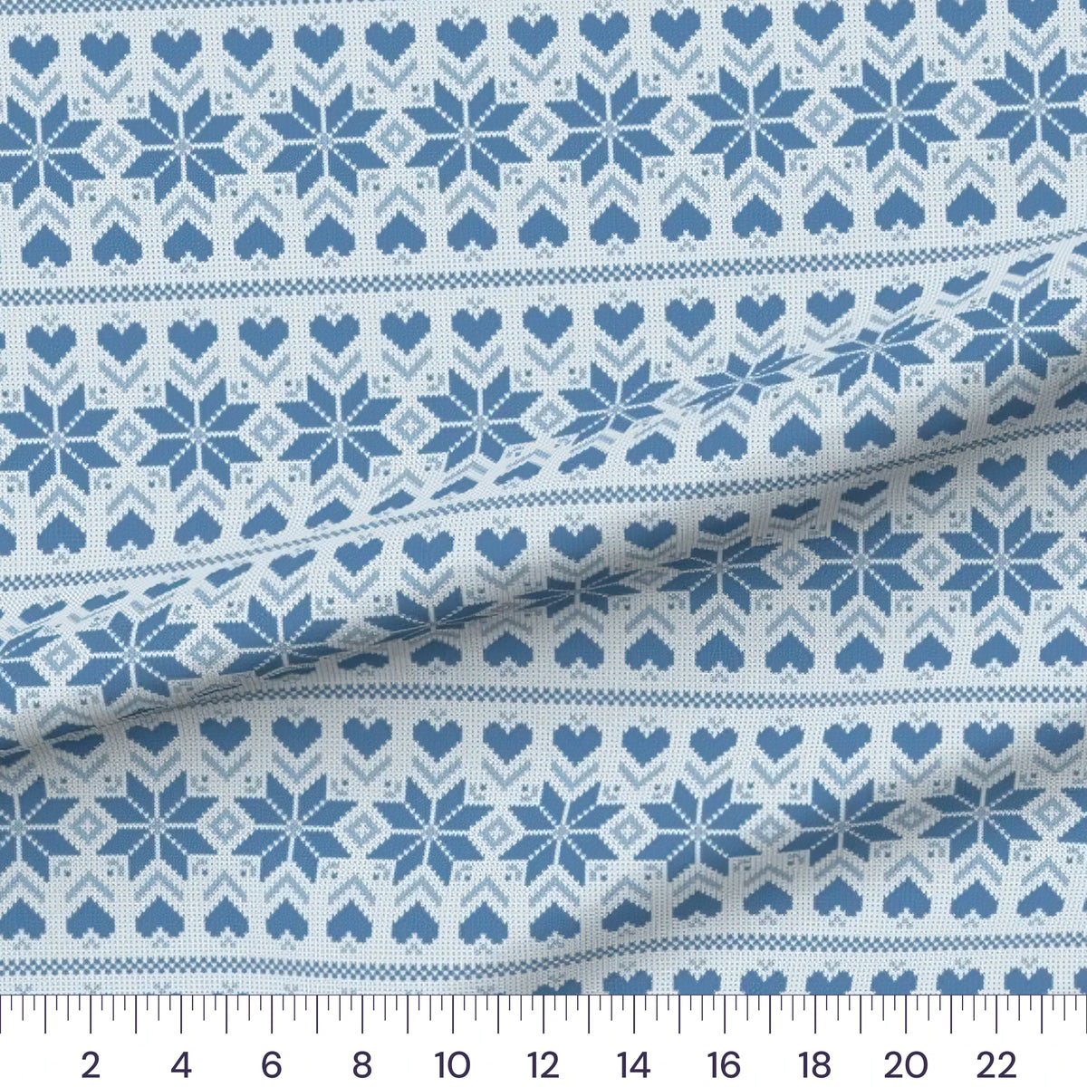 Blue Fair Isle quilting cotton fabric – draped close-up with a ruler showing true print scale