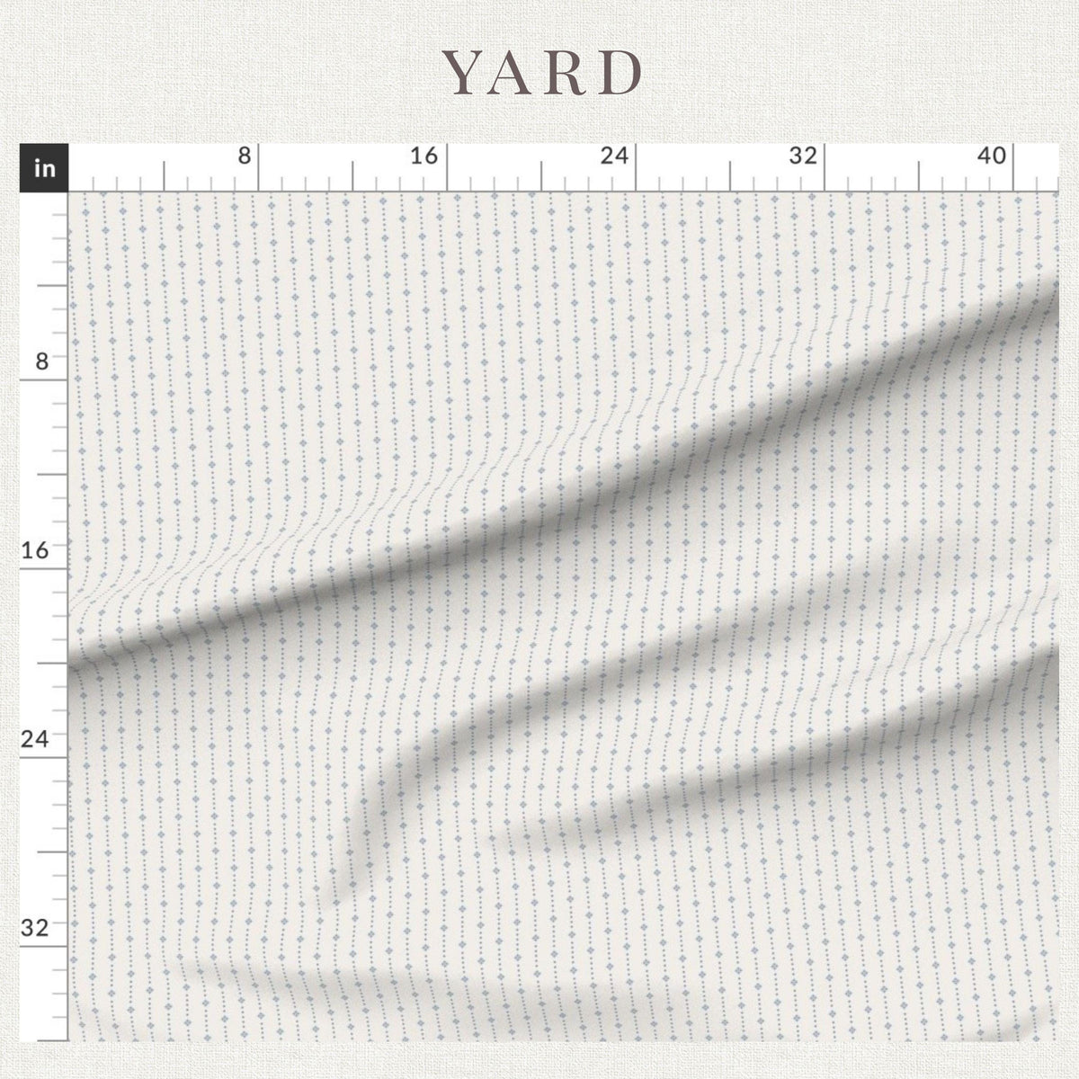 Blue on Ivory ditsy star stripe fabric beside a ruler showing the print scale