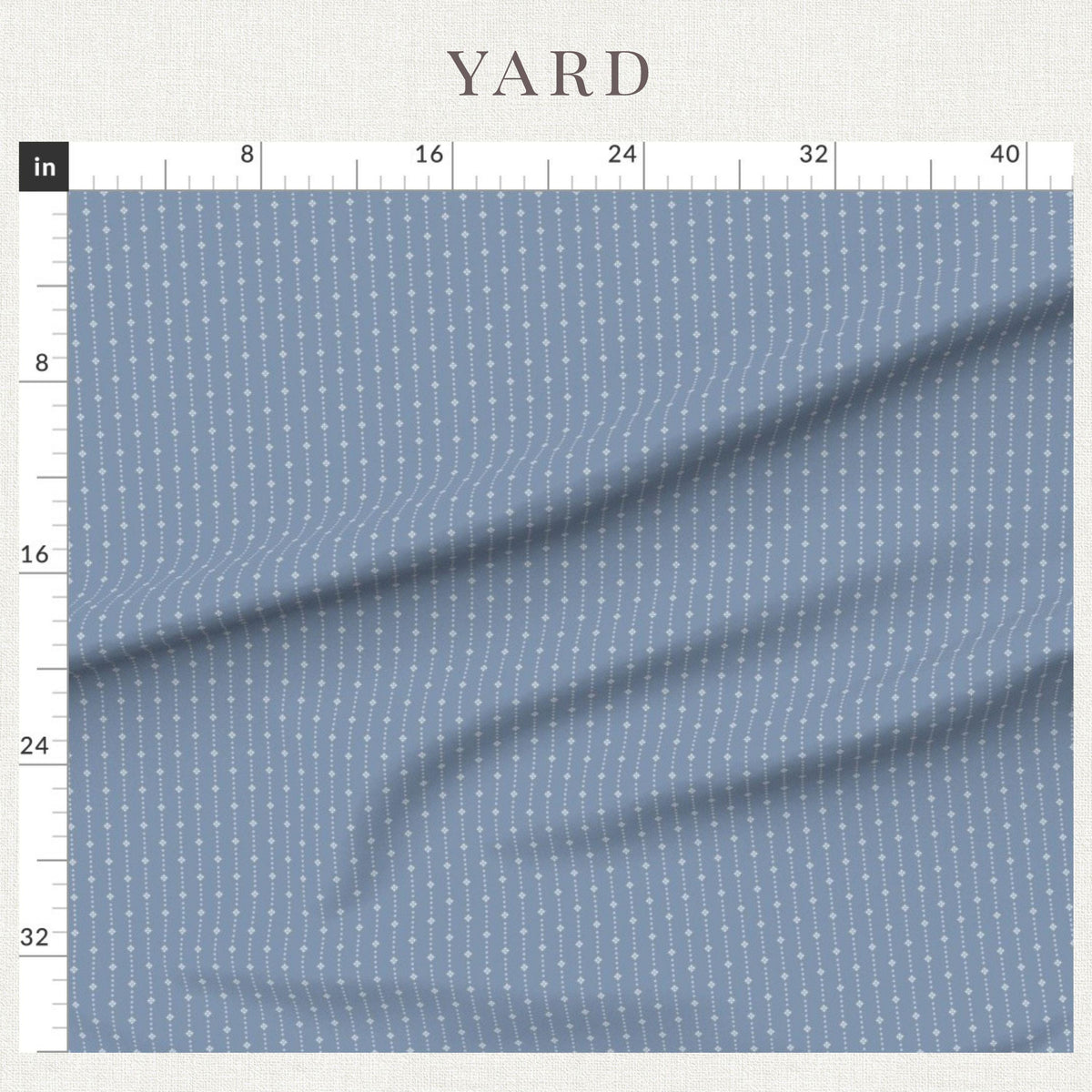 Ivory on Blue ditsy star stripe fabric beside a ruler showing the print scale