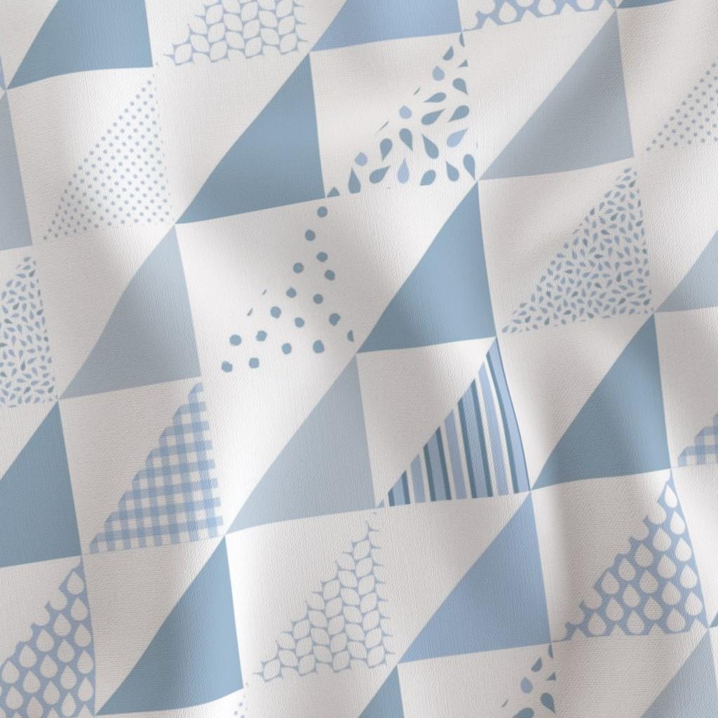 Diagonal half-square triangle arrangement in soft blue nursery colors