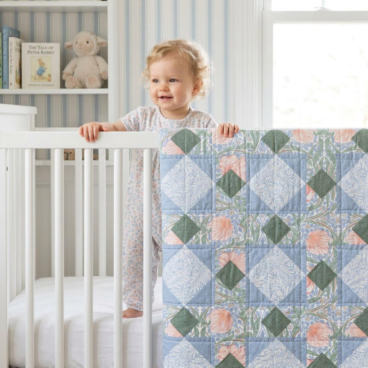 Baby in a crib holding a no-piecing William Morris patchwork quilt