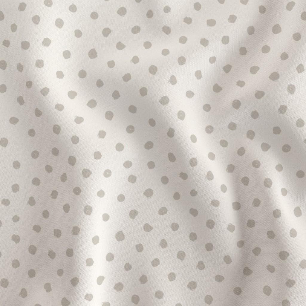 Cream doodle dots quilting cotton draped to show the soft hand and small dot print