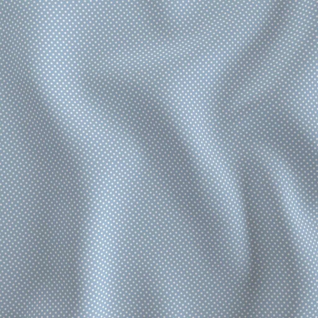 Light blue polka dot fabric showing the tiny dot print on cotton quilting fabric
